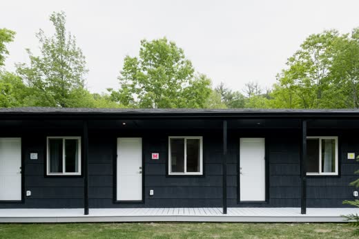 The motel's black-painted exterior on a green lawn