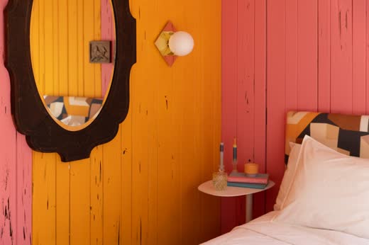 A bedroom with orange and coral painted walls