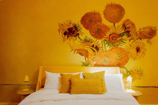 A yellow bedroom with a sunflower painting over the bed