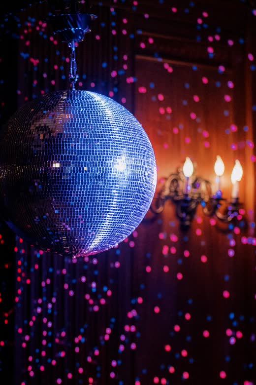 A disco ball throwing light over the dance floor