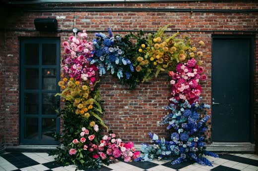 A wall of flowers framing a brick doorway