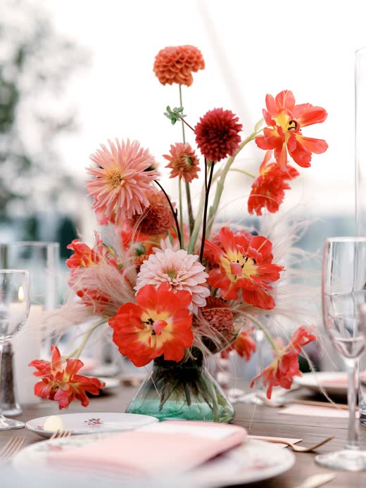 Red and coral blooms on a reception table